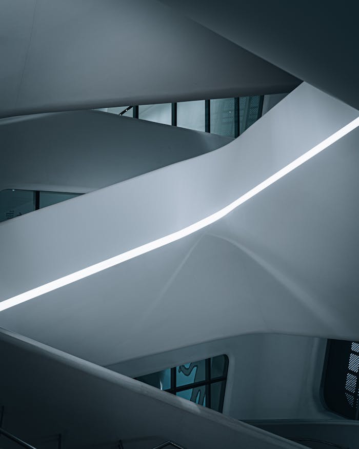 Sleek and modern architectural interior featuring a futuristic curved staircase with minimalist design.