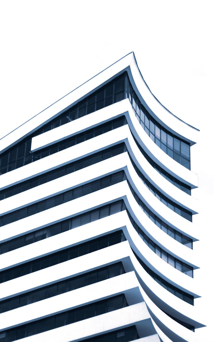 Dynamic view of a modern building with distinctive curved architecture and glass windows.